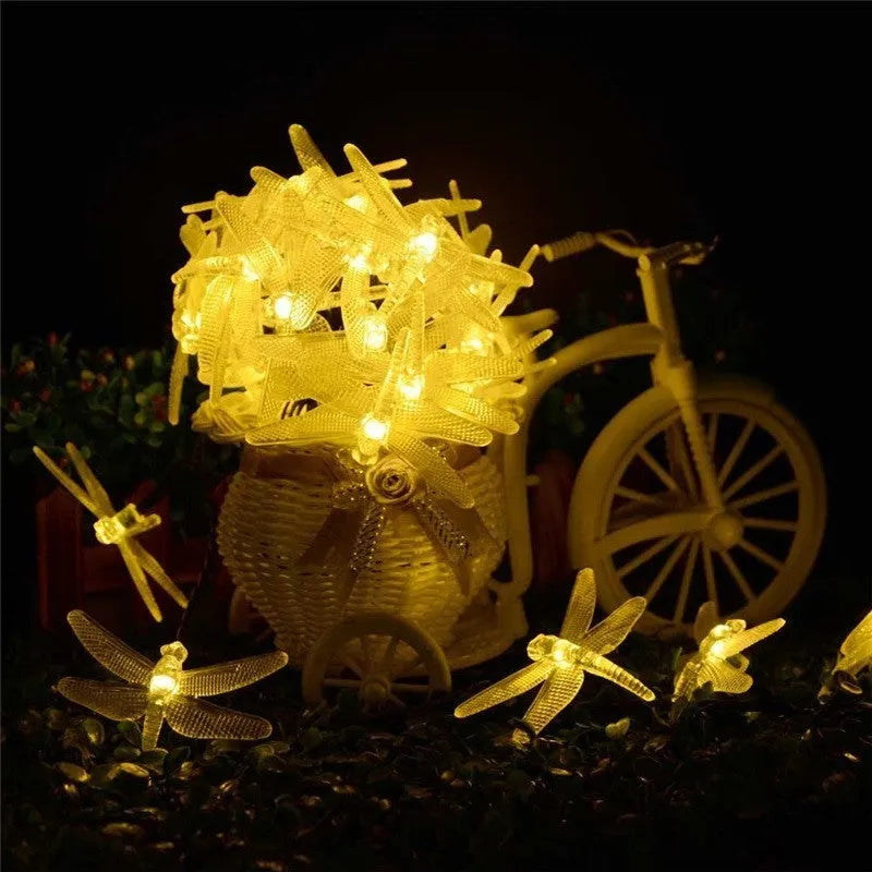 5-metre long solar-powered dragonfly string lights with warm white LEDs and a ground-spike solar panel for outdoor use.