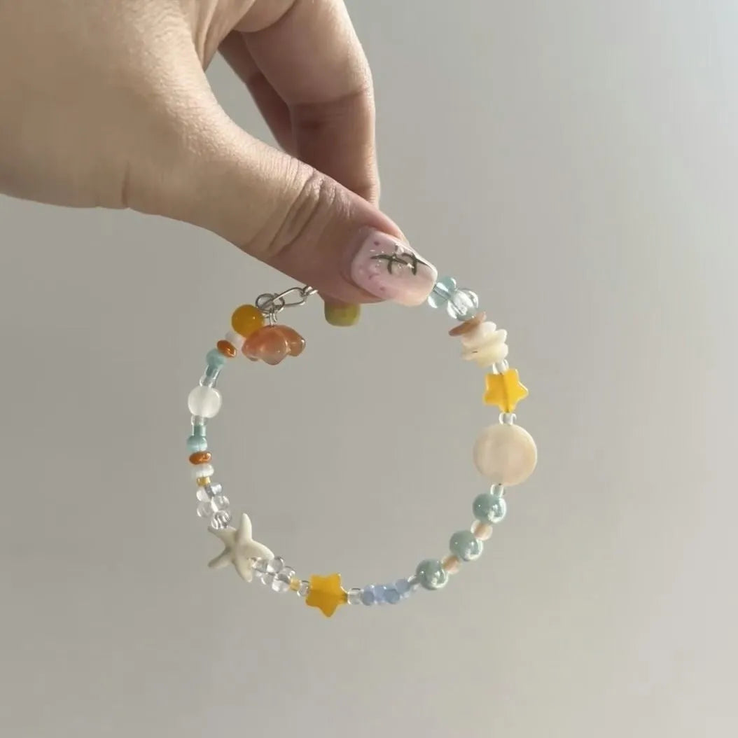 Water-soaked orange sea summer bracelet with diamond shape and round alloy elements for female wearers