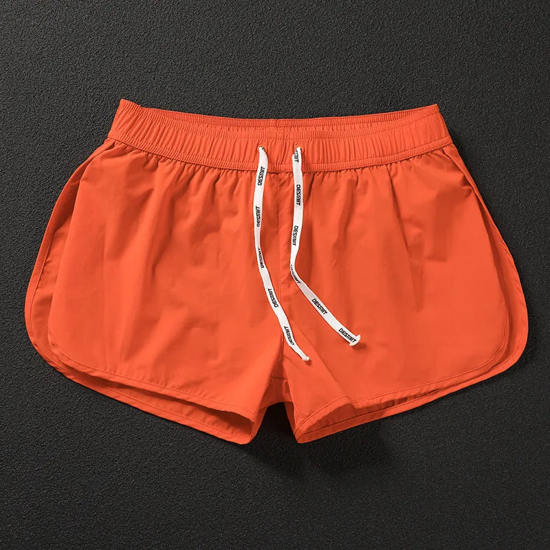 Men's loose beach surfing shorts in orange, fluorescent green, or black with elastic waistband and micro-elastic fabric