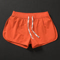 Men's loose beach surfing shorts in orange, fluorescent green, or black with elastic waistband and micro-elastic fabric