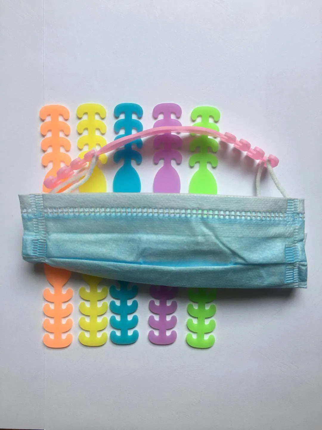 Set of eight small silicone tool buckles in various colours including red, yellow, black, and blue.