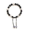Black agate map stone volcanic rock bracelet with diamond-shaped beads on a wrist.