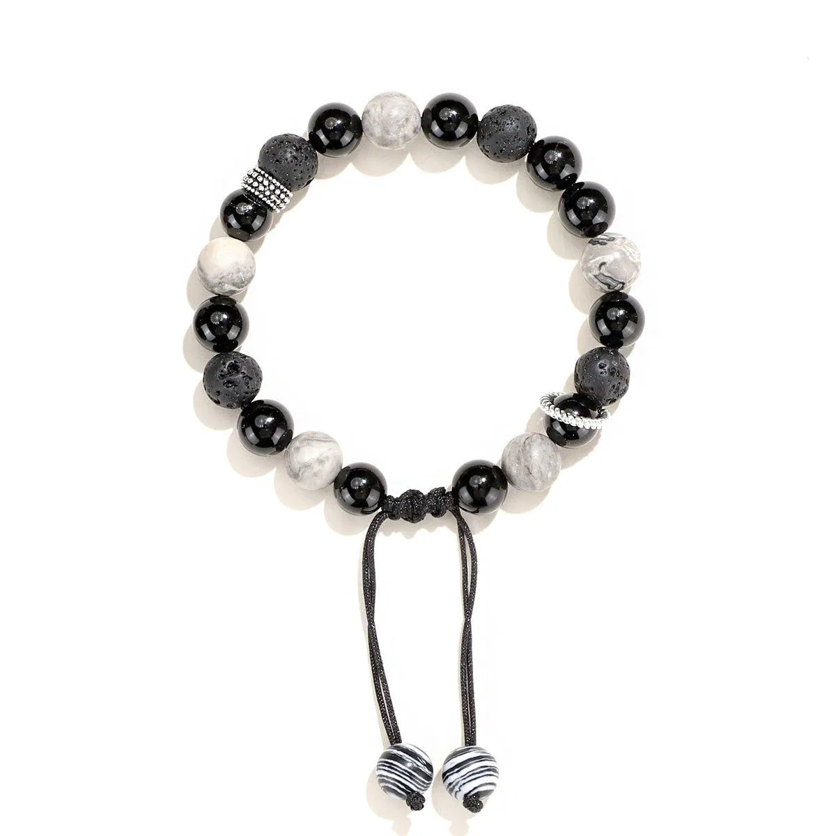 Black agate map stone volcanic rock bracelet with diamond-shaped beads on a wrist.