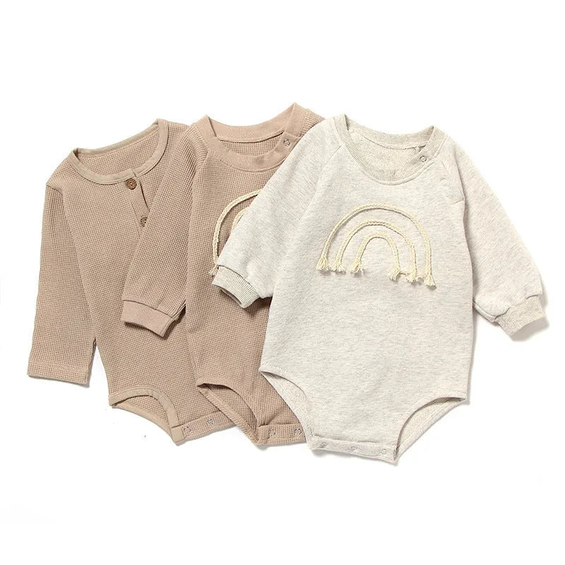 Long sleeve baby romper in waffle cotton fabric, shown in beige with cotton rope tie closure.