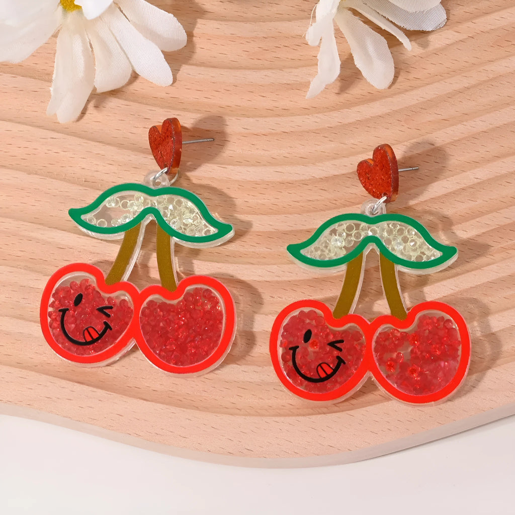 Seven pairs of colourful acrylic fruit and dessert stud earrings on a white background.