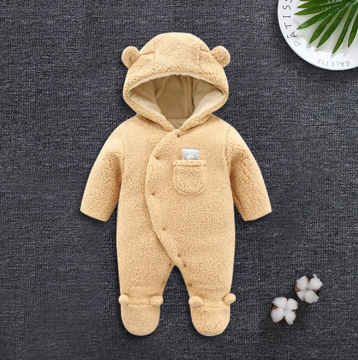 A baby wearing a soft brown cotton lamb-print jumpsuit with long sleeves.