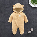 A baby wearing a soft brown cotton lamb-print jumpsuit with long sleeves.