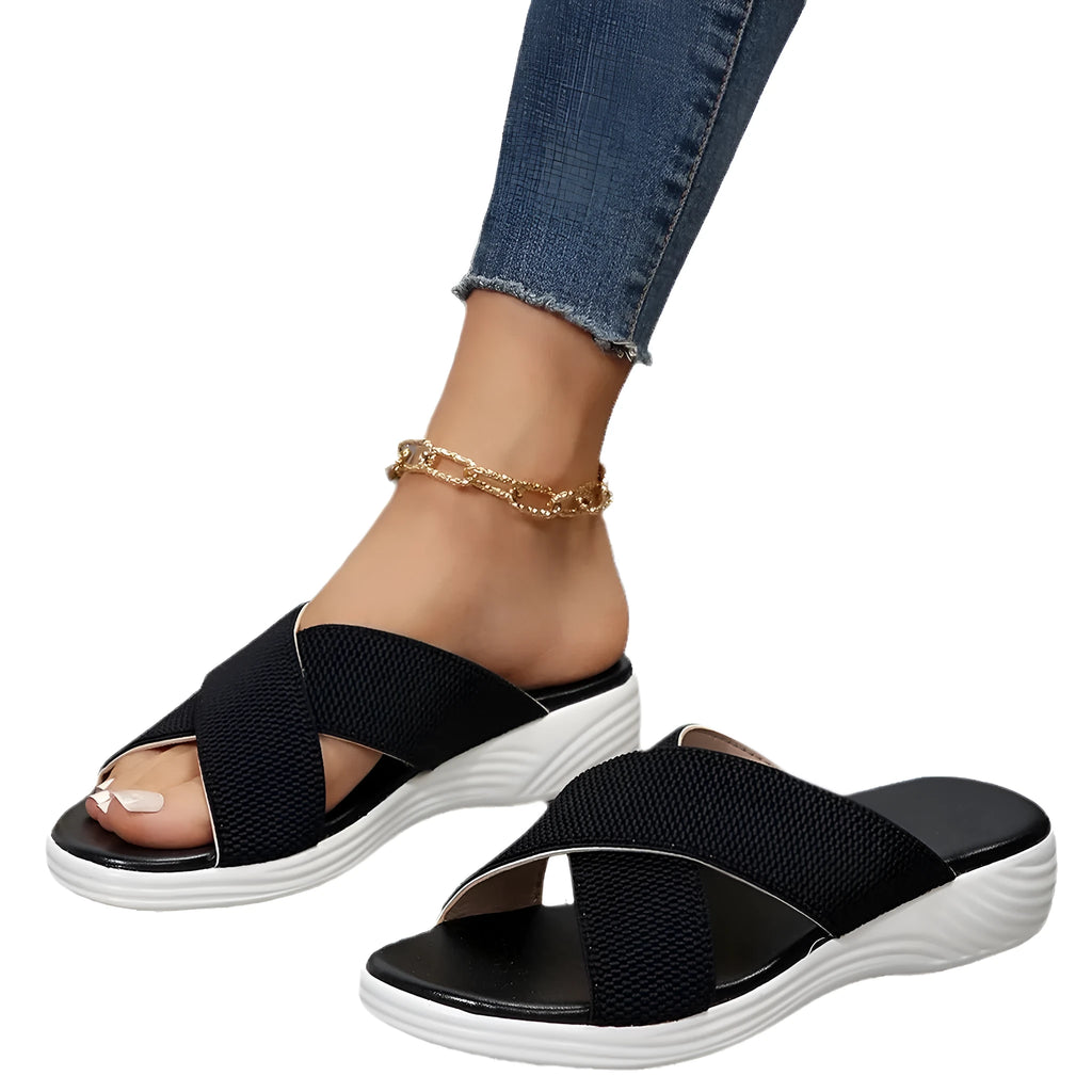 Black women's flat wedge peep-toe slippers with a cross strap and thick rubber sole.