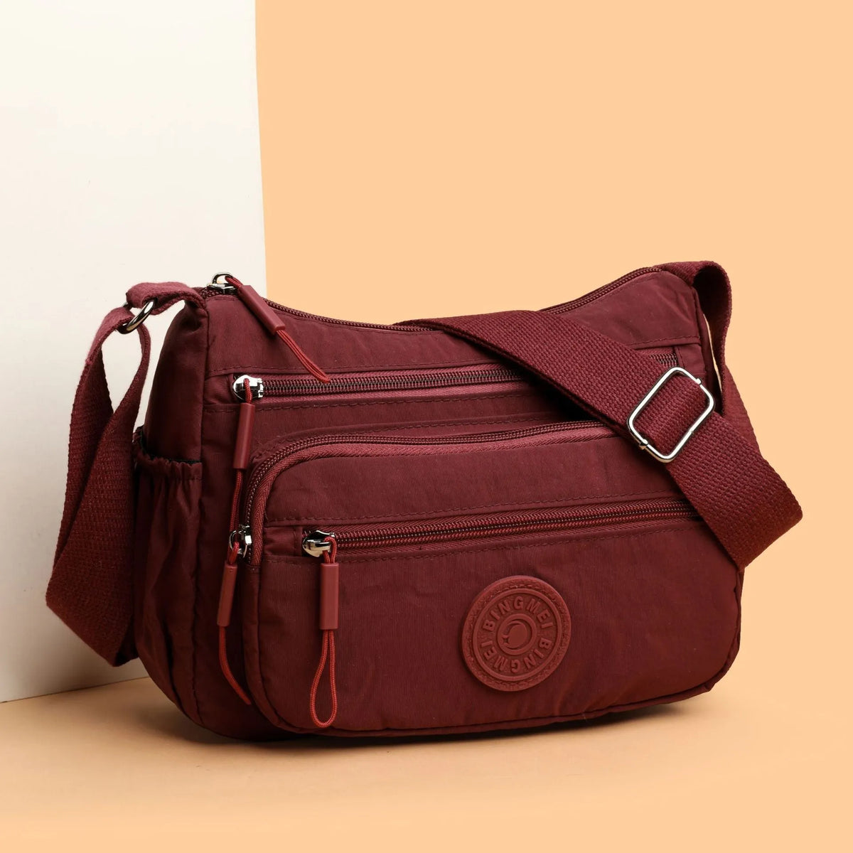 Soft water-repellent nylon crossbody bag in grey with a front 3D pocket.