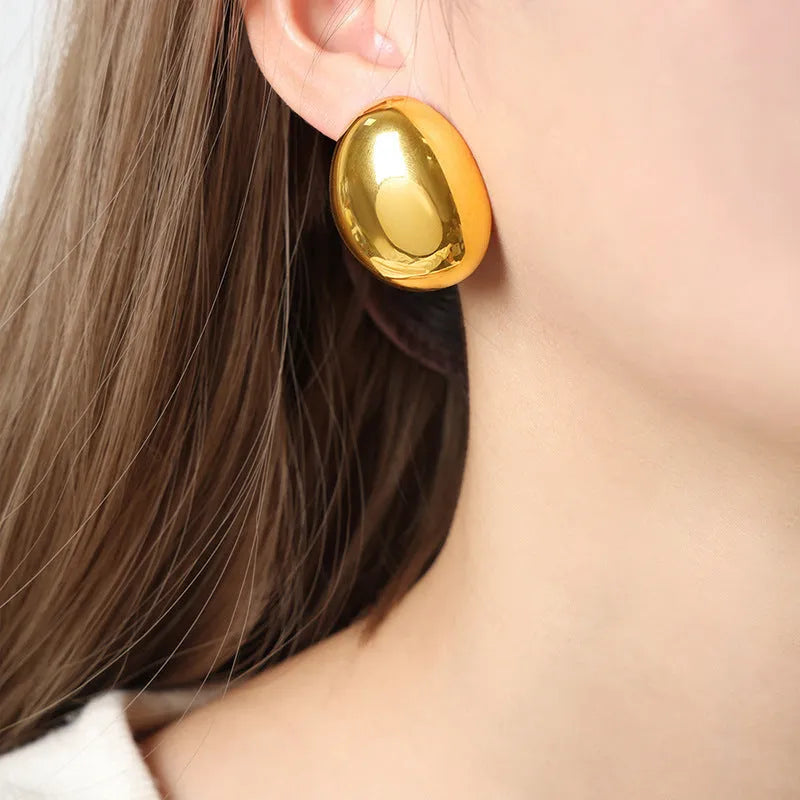 Geometric ear studs with 18K gold electroplating and exaggerated glazed surface showing linear design elements