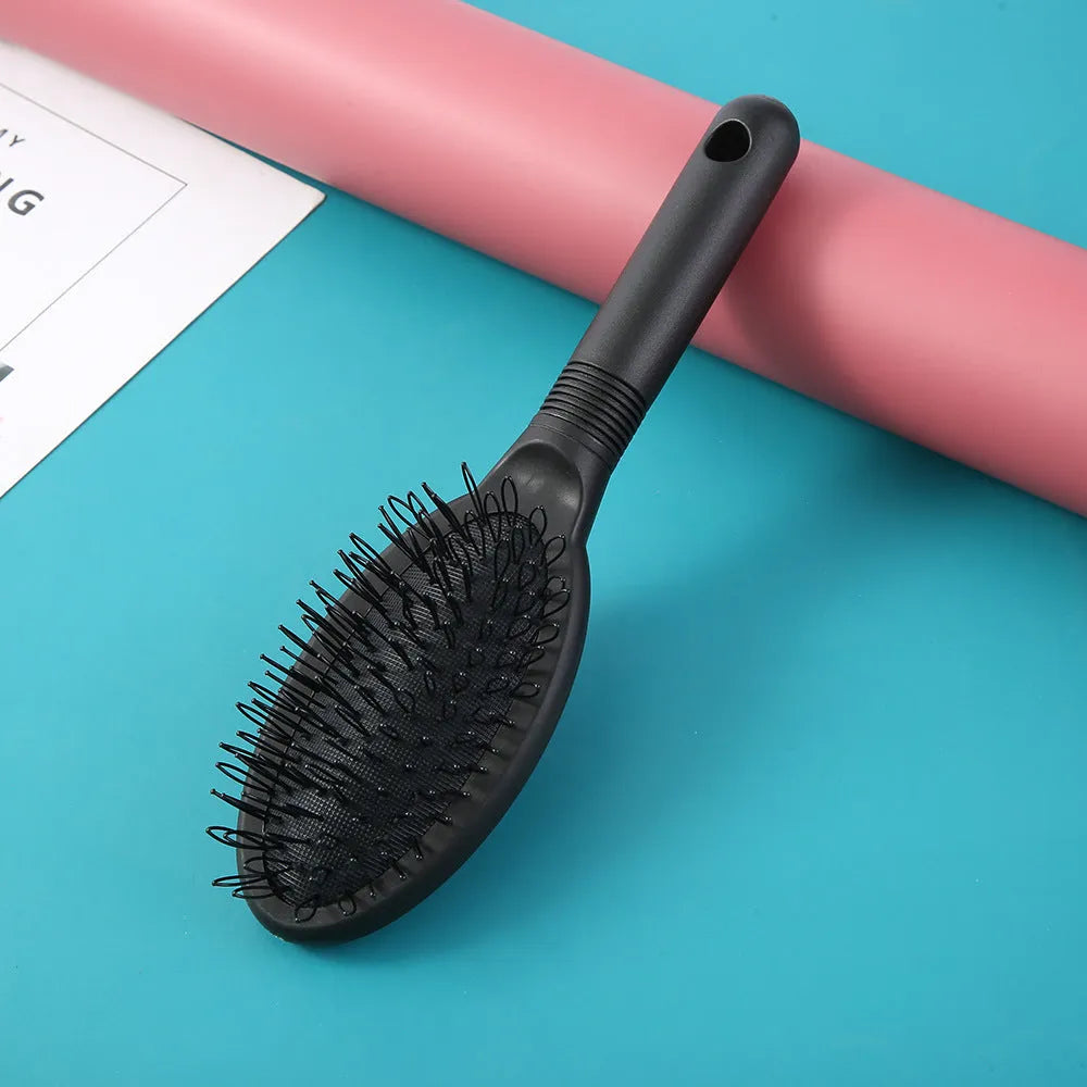 Black and pink ring tooth airbag comb for hair extensions on a white background