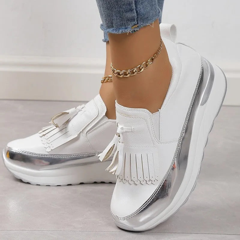 Women's black casual platform shoes with a tassel and muffin wedge heel on a white background.