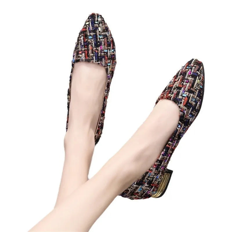 Women's black and white floral patterned canvas casual shoes with a pointed toe and flat rubber sole.