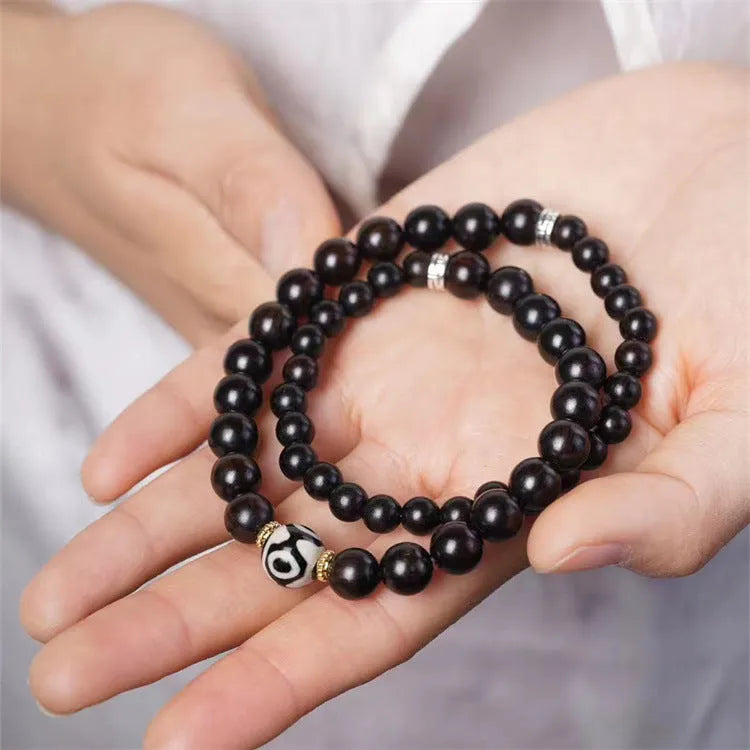 Solid ebony wood Tibetan bead bracelet with two circular 8mm beads on wrist