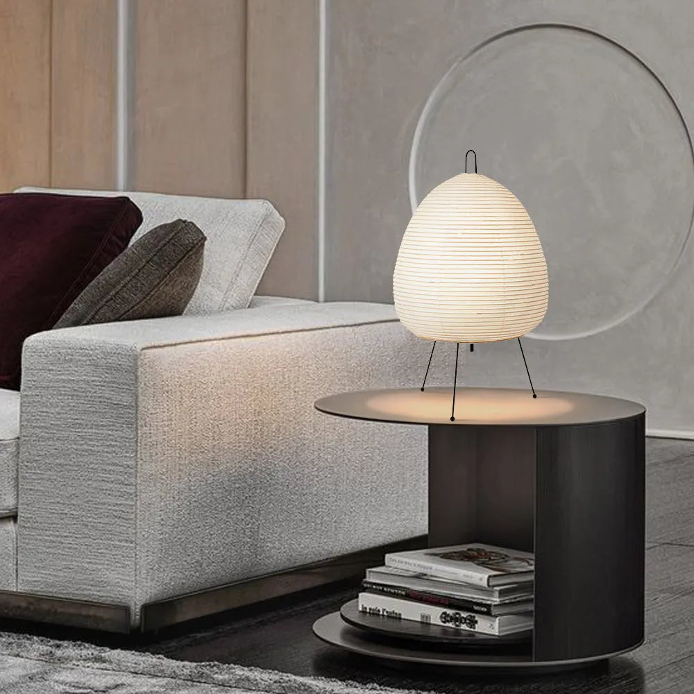 Japanese style rice paper table lamp with aluminium base on a wooden surface.