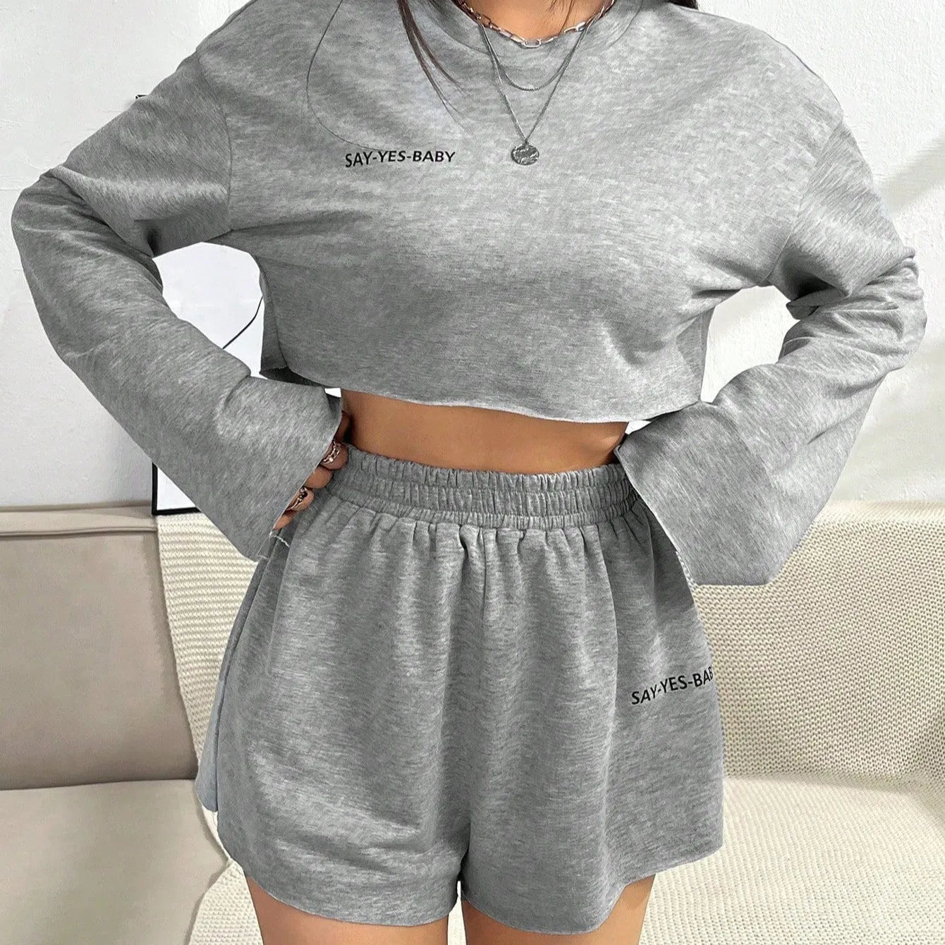 Grey women's long-sleeved polyester top and shorts casual suit set laid flat.
