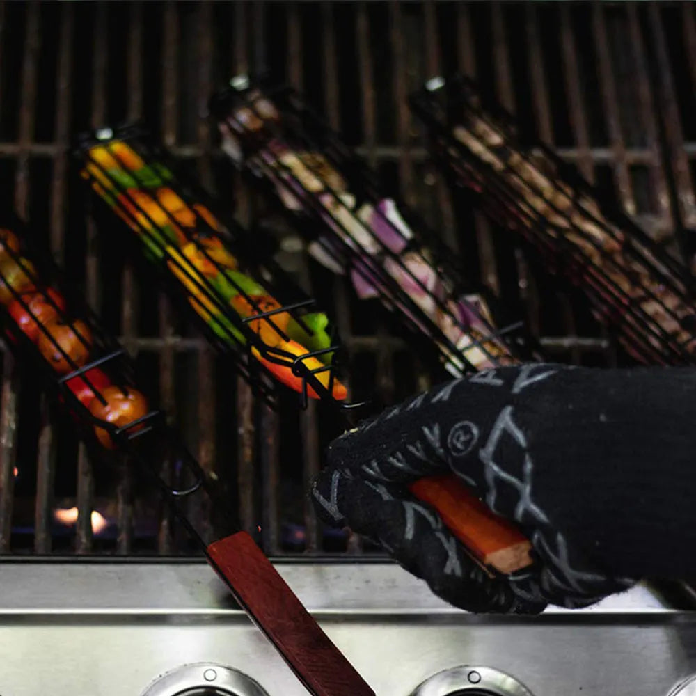 Burlywood coloured iron barbecue basket with a long wood handle for outdoor grilling.