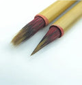 Small red-haired writing brush with a 23cm long handle on a flat surface.