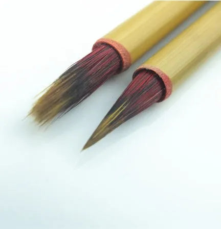 Small red-haired writing brush with a 23cm long handle on a flat surface.