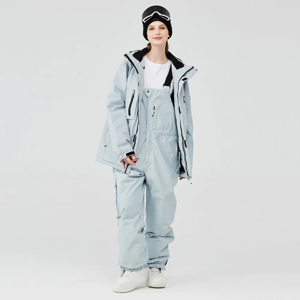 Men's and women's winter ski suit in blue top with grey-blue pants, showing waterproof construction for snow sports