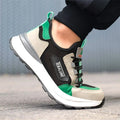 Black and green low-top safety shoes with mesh panels and a steel toe cap on a white background.