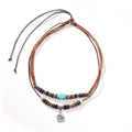 Turquoise wax rope necklace with geometric alloy pendant featuring floral engraving details