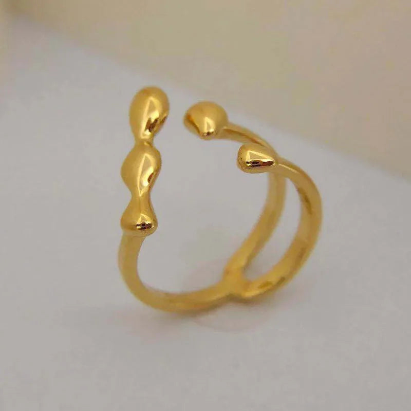 Adjustable brass fashion ring with spherical design in gold finish on hand