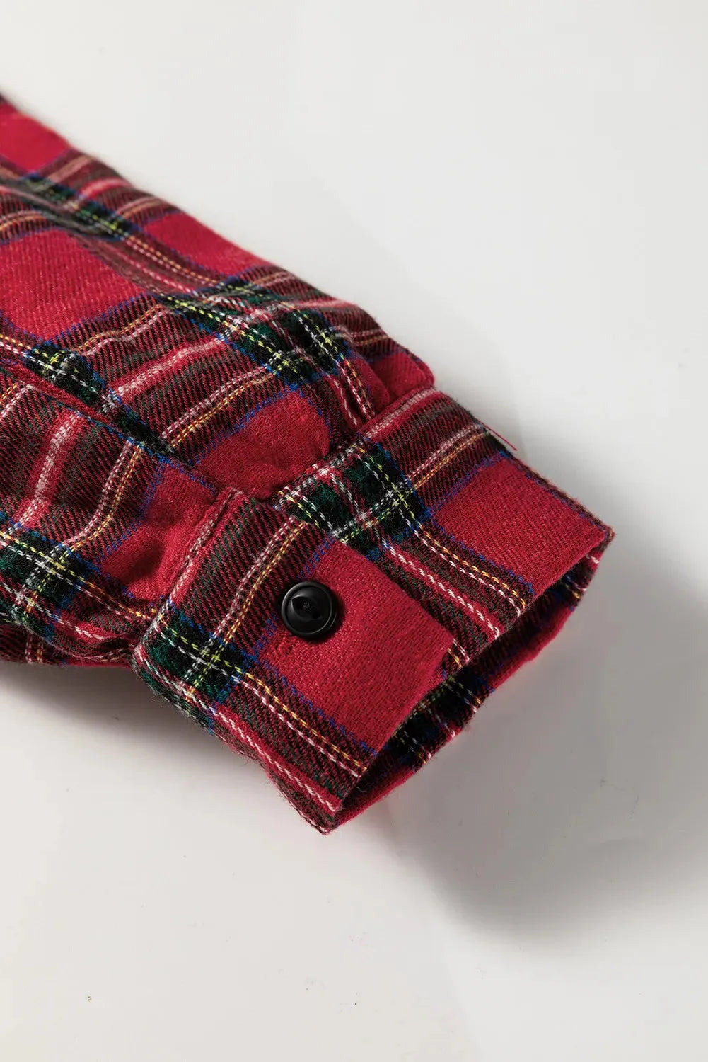 Red and black plaid mini dress with a shirt collar, half-button front, long sleeves, and a ruffle hem.