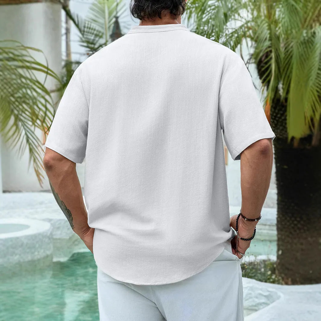 Man wearing a deep V-neck short sleeve casual shirt in a solid colour.