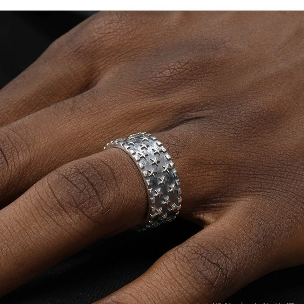 Adjustable sterling silver ring with engraved five-pointed star geometry patterns on a hand