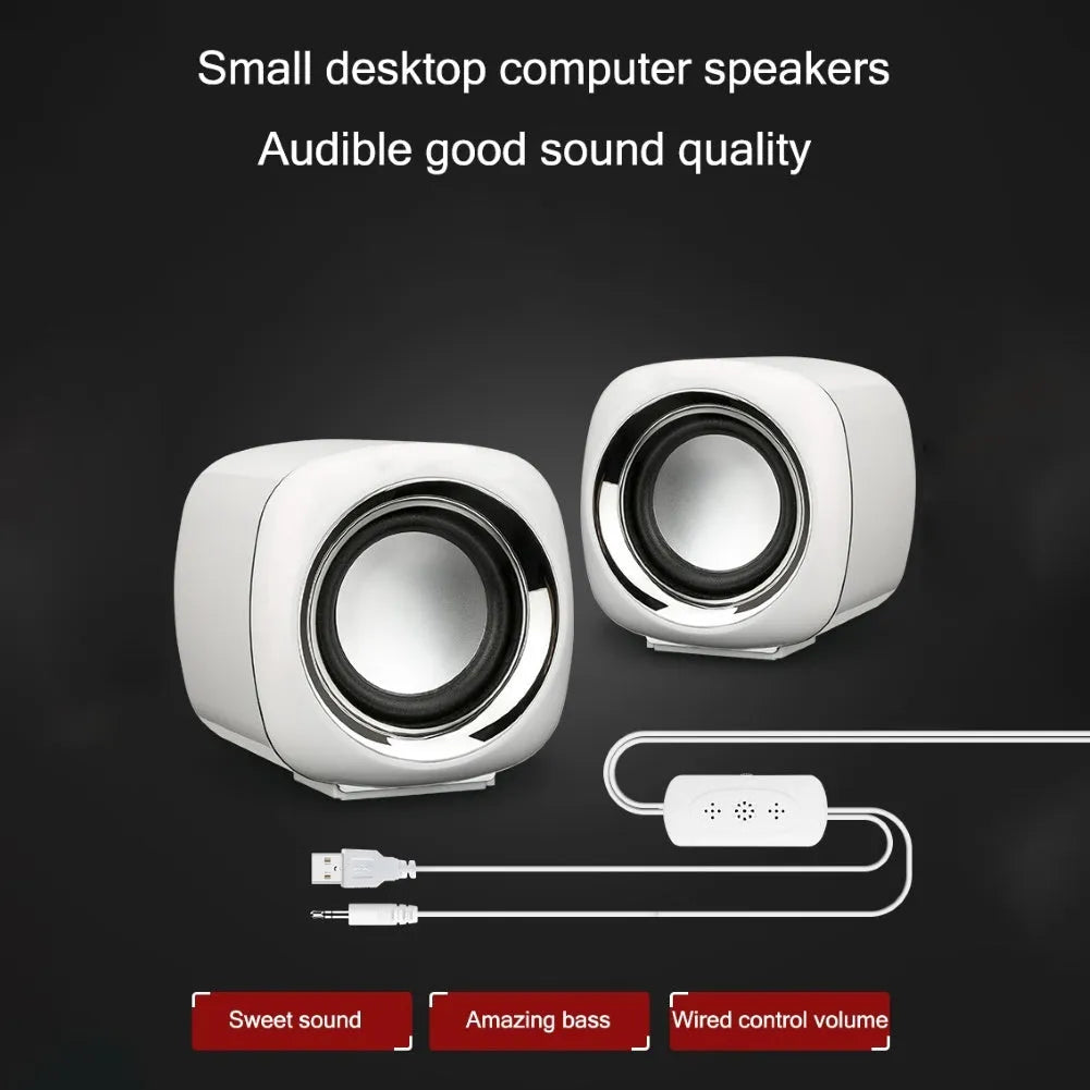 Pair of black wired mini desktop speakers with 3.5mm plug, showing compact cubic shape.
