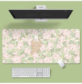 Large rectangular flower pattern mouse pad on a desk with keyboard and mouse.
