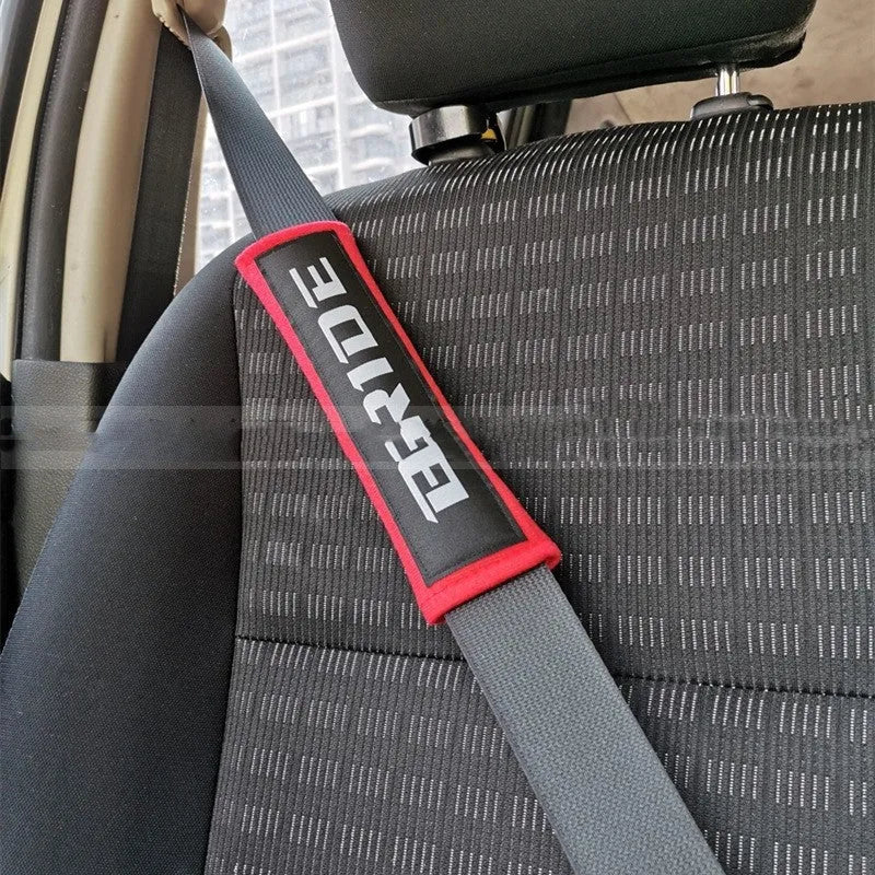 Pair of black sponge cloth car seat belt shoulder protector covers on a car seat.