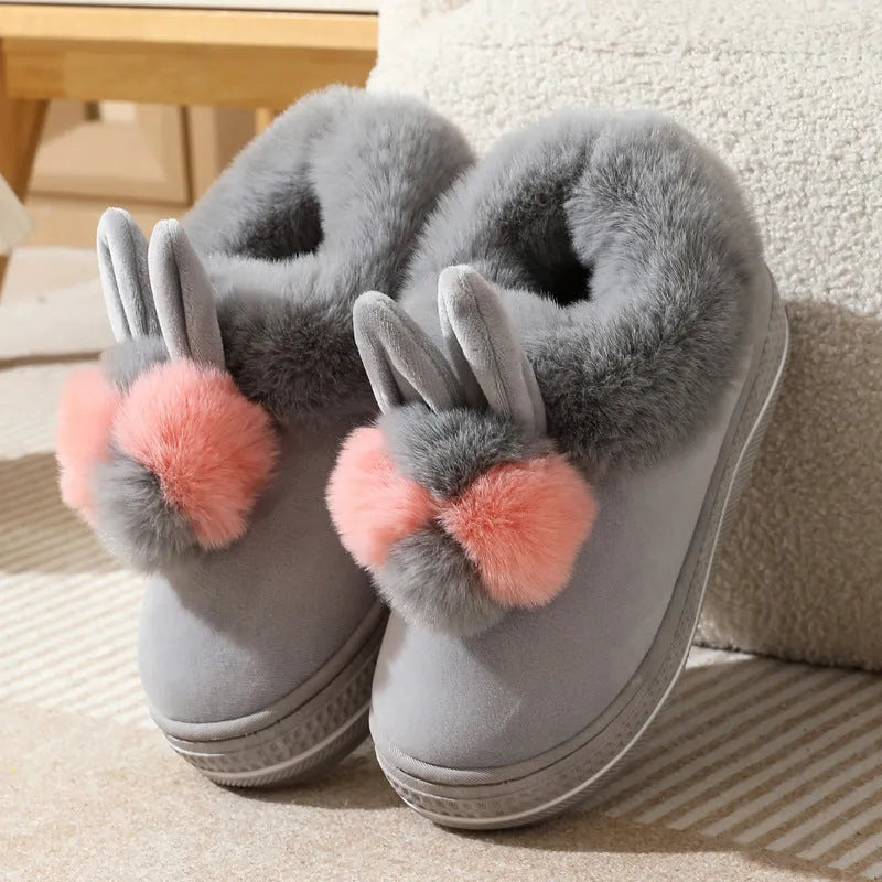 A pair of grey high heel winter slippers with a thick sole and plush upper, shown on a white background.