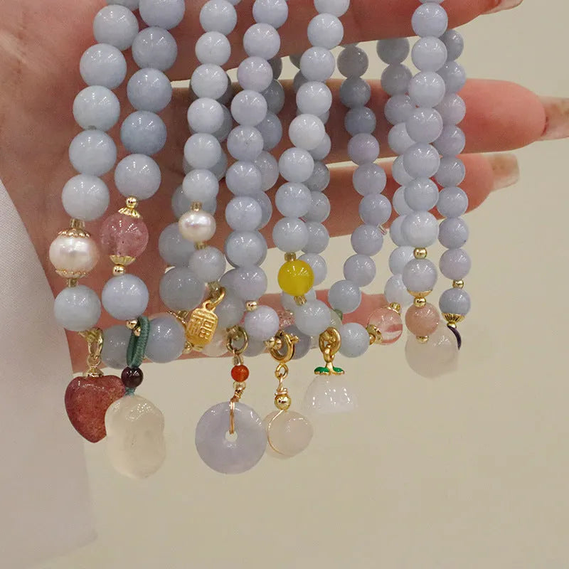 Women's gold plated crystal bracelet with aquamarine chalcedony charm on wrist