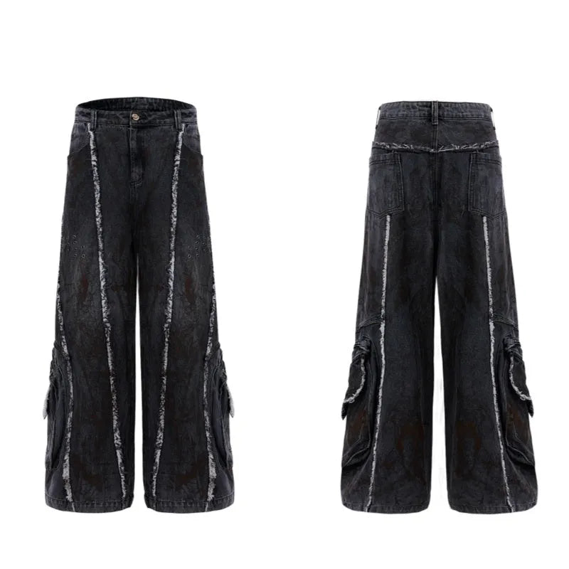 Black gradient denim coat with distressed raw edges and padded shoulders, worn with matching black denim trousers.