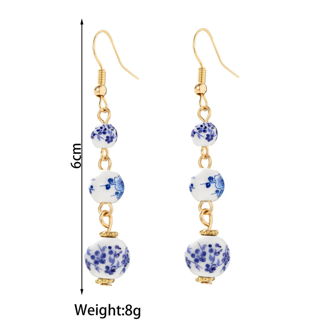 Long blue and white porcelain ceramic bead retro geometric earrings with alloy electroplated frame.