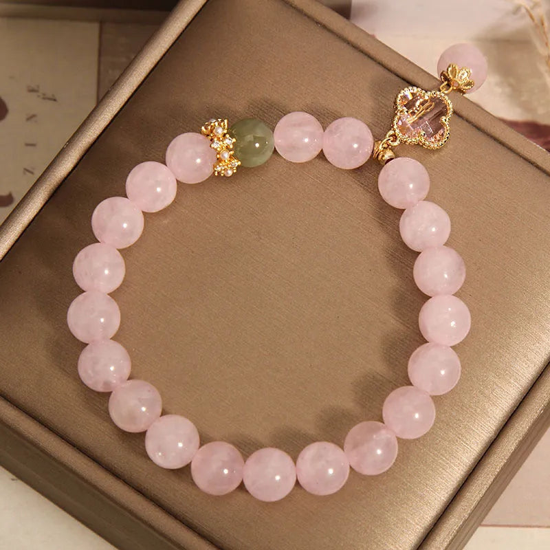 Pink crystal bracelet with four-leaf clover pendant and rhinestone details