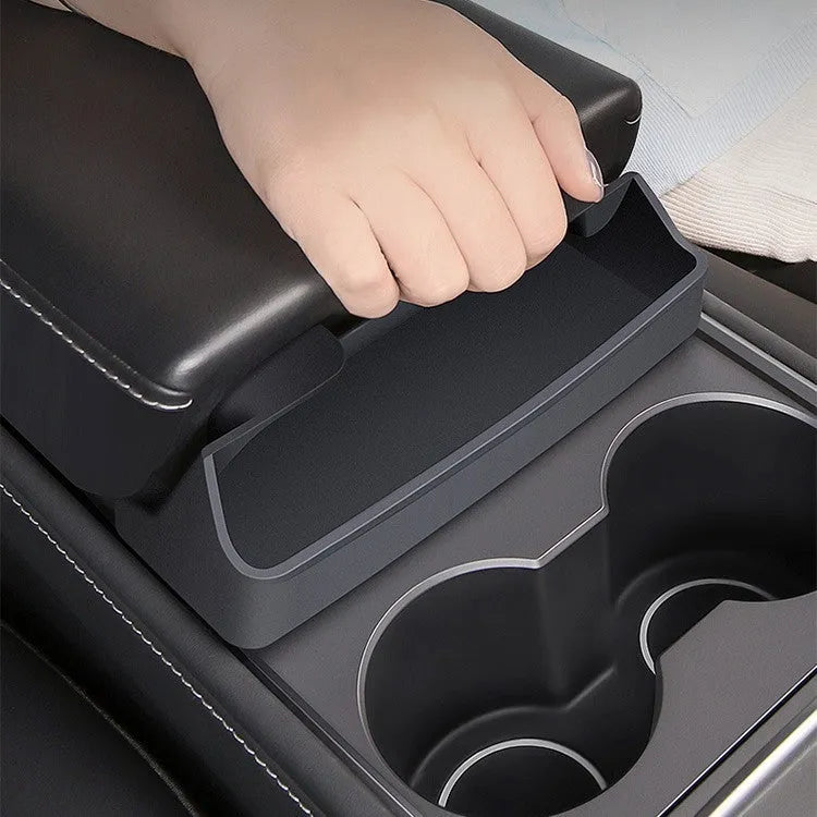 Black silicone sunglasses case installed inside a Tesla Model 3 or Y centre console armrest.