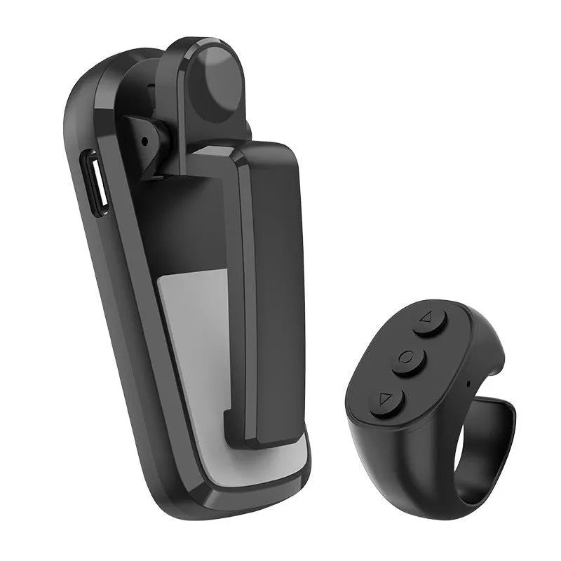 Black wireless page turner remote control and a small clicker on a wooden table.
