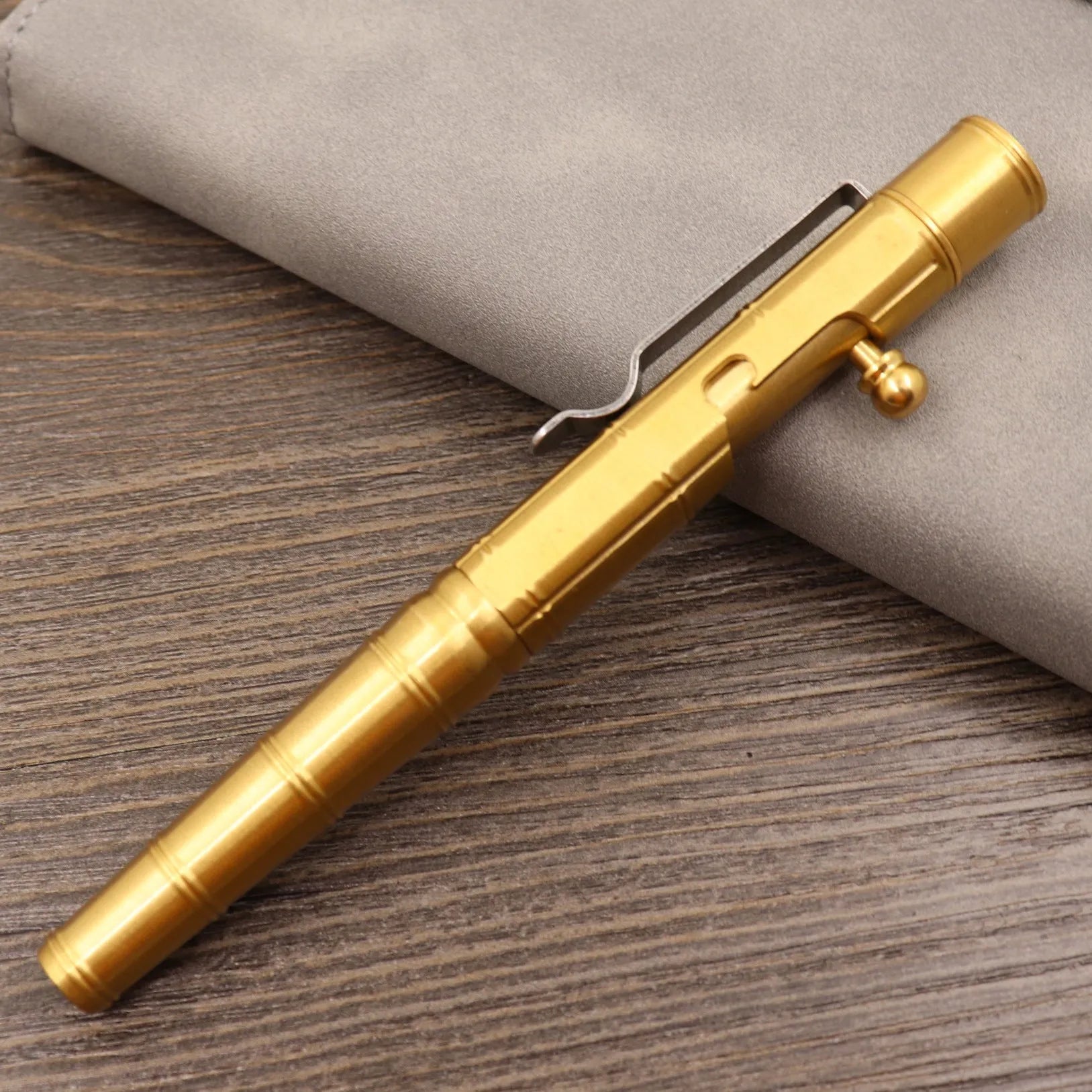 Solid brass bolt-action tactical pen shown in a brass finish with a cylindrical barrel.