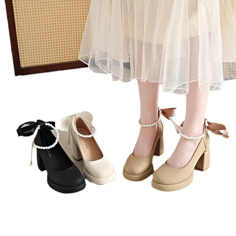 Beige women's Mary Jane shoes with a chunky heel, round toe, and pearl-decorated ankle strap buckle on a white background.
