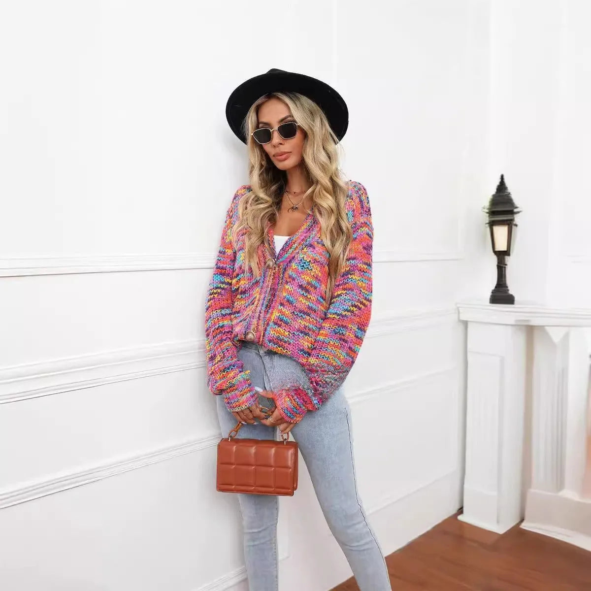 Rainbow striped loose fit knitted cardigan coat on a hanger, rose red with multicolour stripes.