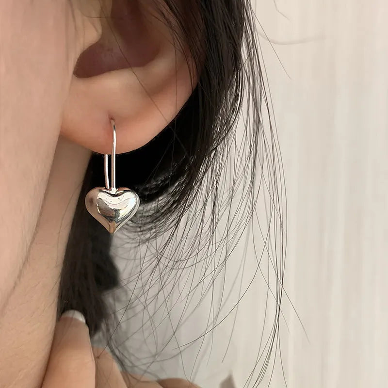Heart-shaped copper earrings with white gold plating and glossy finish, showing three-dimensional design