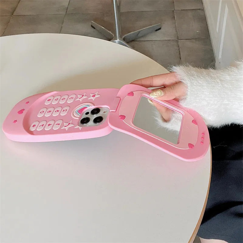 Flip phone shape mirror case for iPhone with silicone construction in light pink colour showing integrated mirror and flip cover design