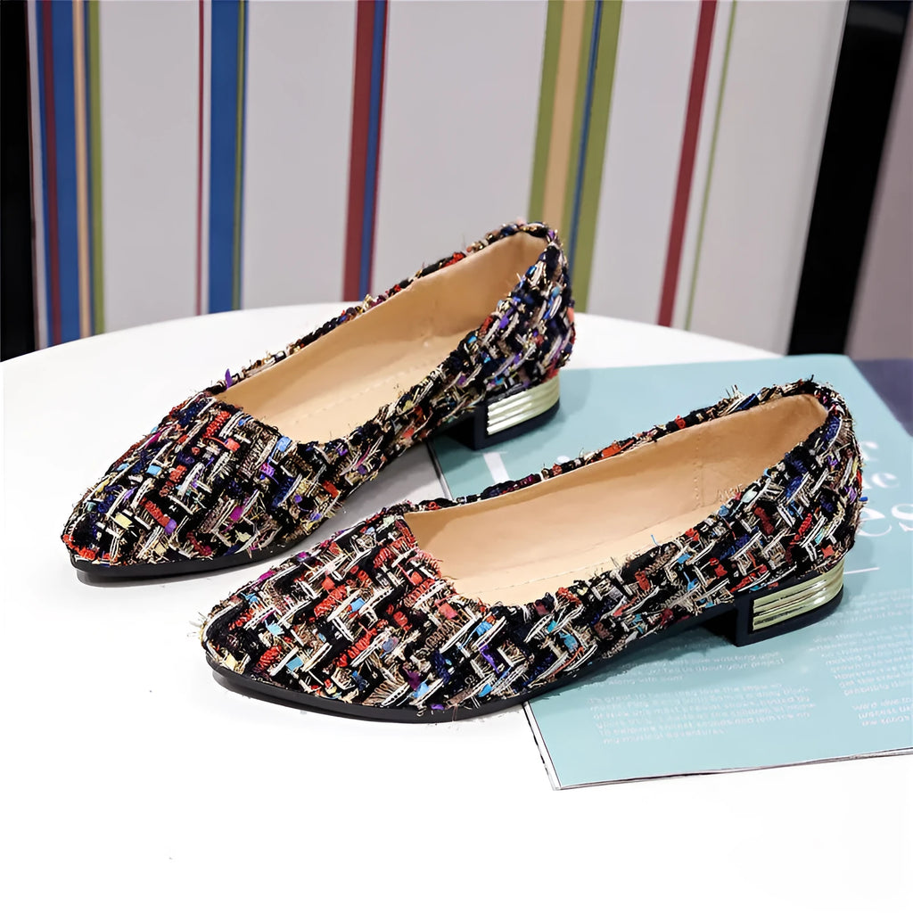 Women's black and white floral patterned canvas casual shoes with a pointed toe and flat rubber sole.