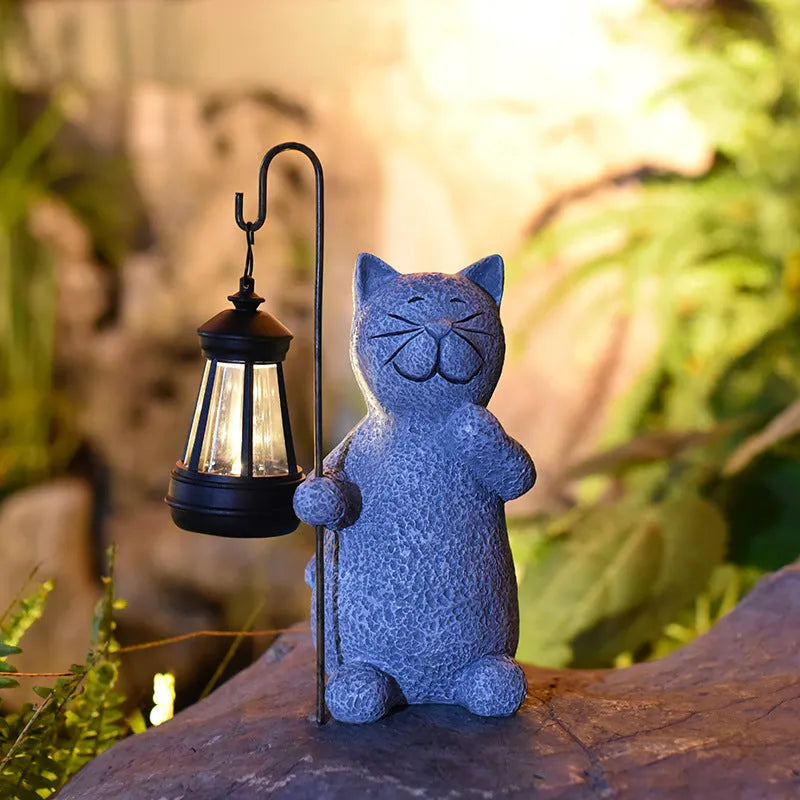 Solar garden light featuring a resin sculpture of a kitten holding up a lantern.