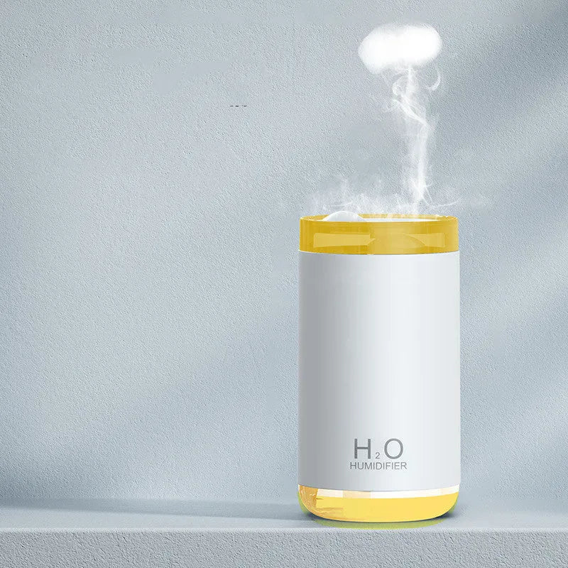 White jellyfish humidifier with blue lighting on wooden table showing mist emission