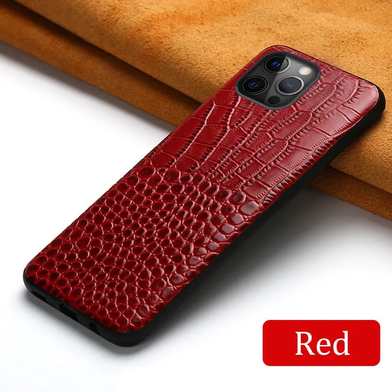Handmade leather iPhone case with crocodile pattern texture in brown colour on a table.