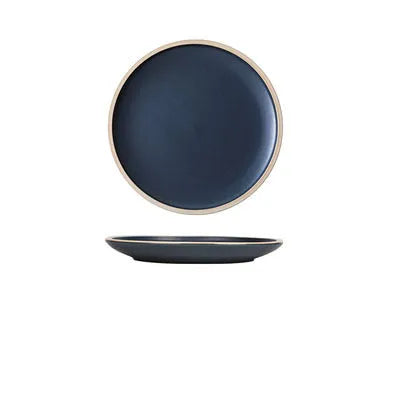 A 10-inch diameter pure blue matte ceramic dinner plate with a subtle textured finish on a wooden table.